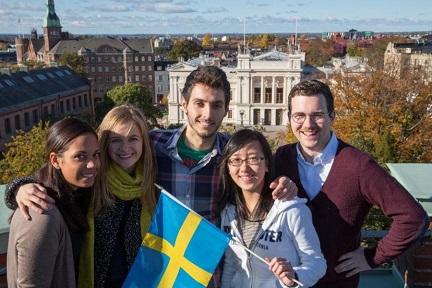 Exchange students with a Swedish flag and the city of Lund in the background