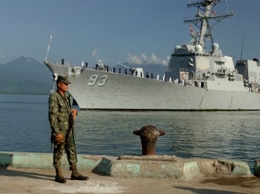 An Armed Forces of the Philippines marine sentry stands watch as the guided-missile destroyer USS Chung-Hoon arrives in Puerto Princesa to participate in Cooperation Afloat Readiness and Training