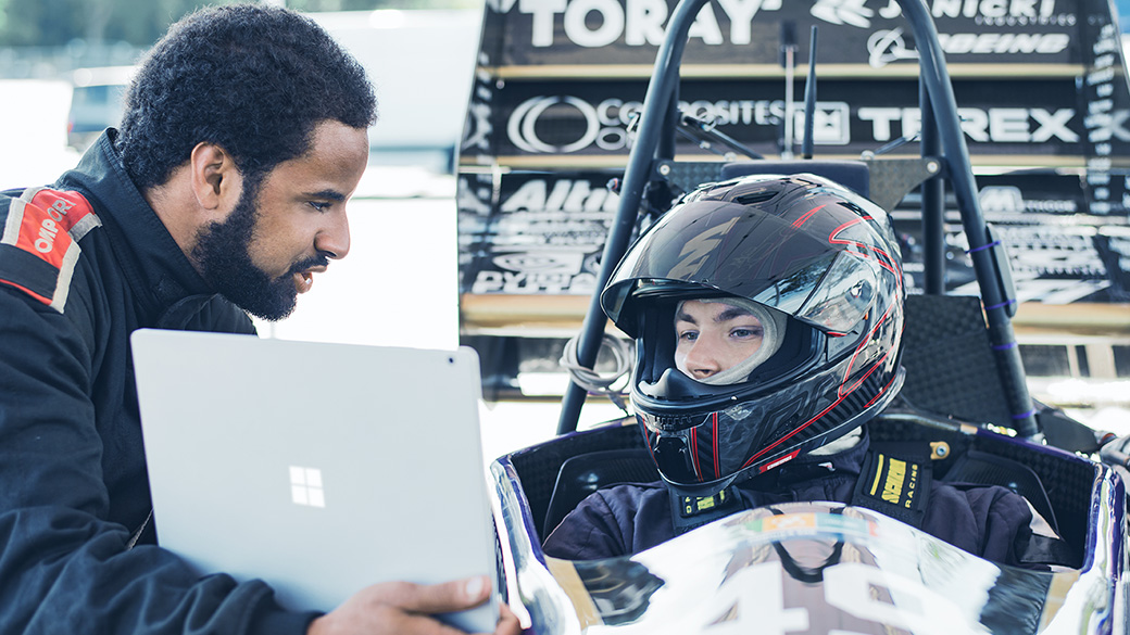 Image of Formula 1 racing team looking at the Surface Book.