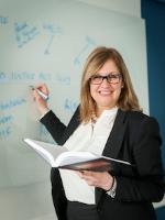 Associate law lecturer Louise Pinder, poses at a whiteboard