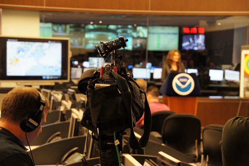 Image of media setting up for a news conference at a NOAA facility