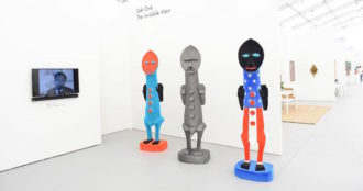 Zak Ové's "Invisible Men" inside the Untitled Art Fair features three figures with Afircan masks with their hands up