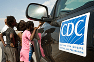 	Haitian children in front of a CDC vehicle.