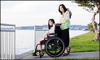 Picture of a young women in a wheelchair accompanied by her mother