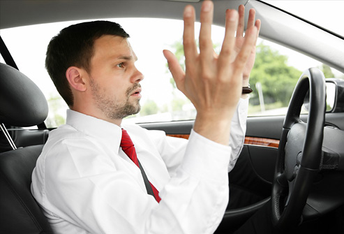 Driver raising hands in frustration in traffic