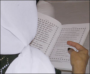 Woman reading from the Guru Granth Sahib