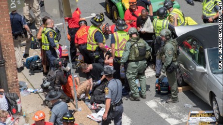 People receive first-aid after a car accident ran into a crowd of protesters in Charlottesville, Virginia on August 12, 2017. 