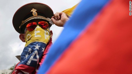 In this Sunday, Aug. 6, 2017 photo, an anti-government demonstrator wearing a Russian military hat protests the government of Venezuela&#39;s President Nicolas Maduro in Caracas, Venezuela. Venezuelan ruling party chief Diosdado Cabello said the military squashed a &quot;terrorist&quot; attack at a military base on Sunday, shortly after a small group of men dressed in military fatigues released a video declaring themselves in rebellion. (AP Photo/Wil Riera)