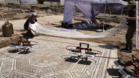 Archaeologists work on a mosaic on July 31, 2017, on the archaeological antiquity site of Sainte-Colombe, near Vienne, eastern France.
Remains of an entire neighbourhood of the Roman city of Vienne have been uncovered in Sainte-Colombe, with lavish residences decorated with mosaics, a philosophy school and shops. The dig of the site, discovered prior to housing construction on a parcel of 5000 m2, began in April 2017 and was due to last six months, but have been extended to December 15, 2017, after the site was classified as an &quot;exceptional discovery&quot; by the French Culture Minsitry. / AFP PHOTO / JEAN-PHILIPPE KSIAZEK        (Photo credit should read JEAN-PHILIPPE KSIAZEK/AFP/Getty Images)