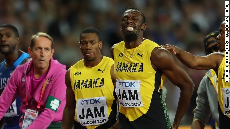 The agony is clear for all to see as Bolt of Jamaica is comforted by teammates. 