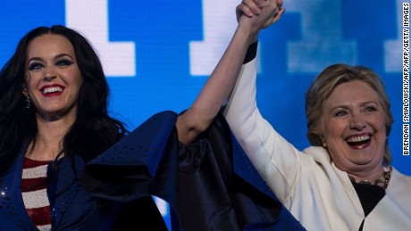 Singer Katy Perry (L) and Democratic presidential nominee Hillary Clinton cheer during a GOTV concert at the Mann Center for the Performing Arts November 5, 2016 in Philadelphia, Pennsylvania. / AFP / Brendan Smialowski        (Photo credit should read BRENDAN SMIALOWSKI/AFP/Getty Images)