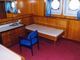 This is one of many beautifully paneled former first class staterooms with twin brass-framed portholes.