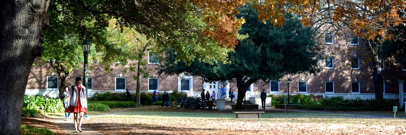 SMU students walking outside a residence hall, fall colors