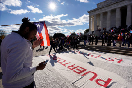 A man participates in the Unity March to highlight the ongoing humanitarian and natural disaster crisis in Puerto Rico, at the Lincoln Memorial in Washington, U.S., November 19, 2017. REUTERS/Yuri Gripas - RC1E578B15E0