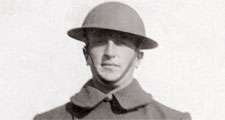 World War I. WWI British or American Army soldier standing in uniform wearing a brodie helmet and an overcoat.
