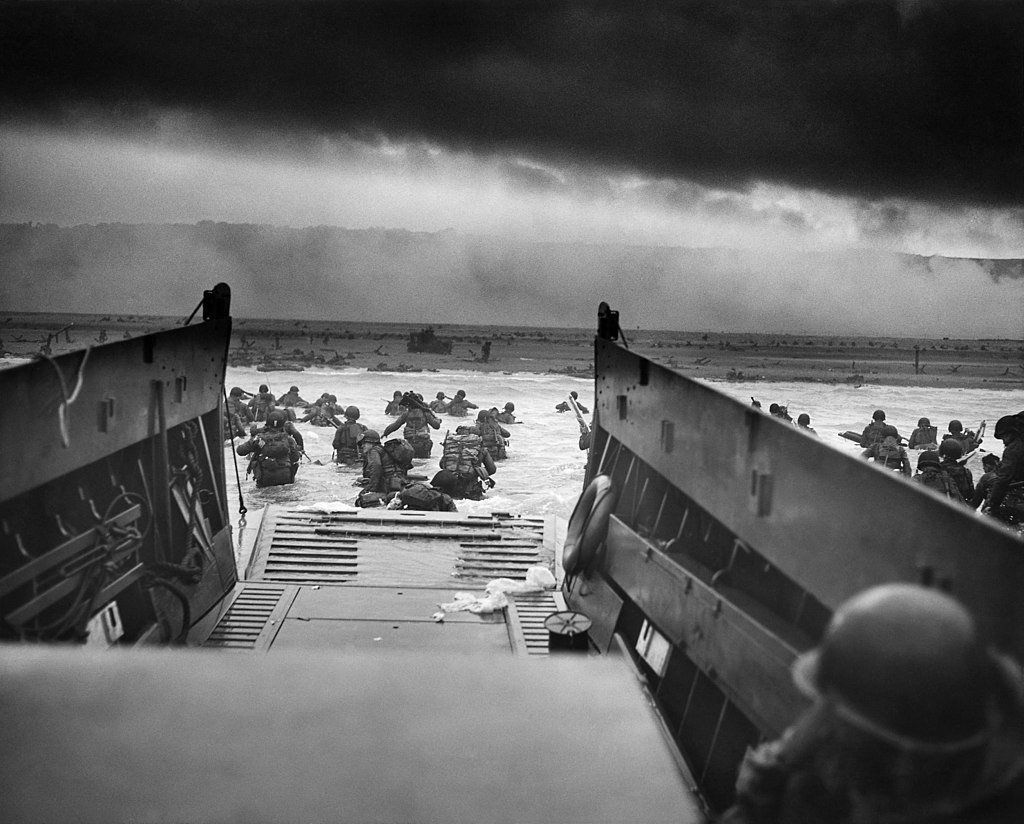 A LCVP (Landing Craft, Vehicle, Personnel) from the U.S. Coast Guard-manned USS Samuel Chase disembarks troops of Company E, 16th Infantry, 1st Infantry Division wading onto Omaha Beach.