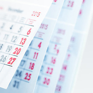 Months and dates shown on a calendar whilst turning the pages with shallow depth of field
