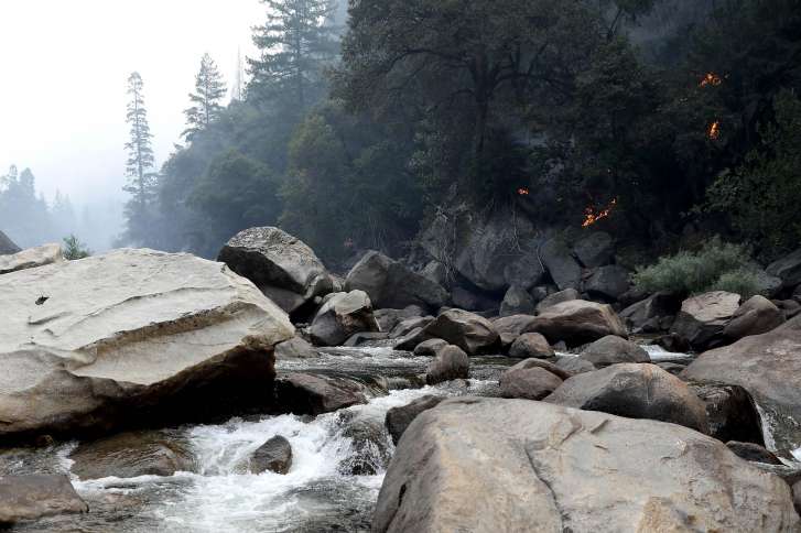 The Ferguson fire burns along a hillside near the Merced River in Yosemite, Calif., on Tuesday, Aug. 14, 2018. The Yosemite Valley reopened as firefighters strengthen containment of the Ferguson fire. (Gary Coronado/Los Angeles Times/TNS)