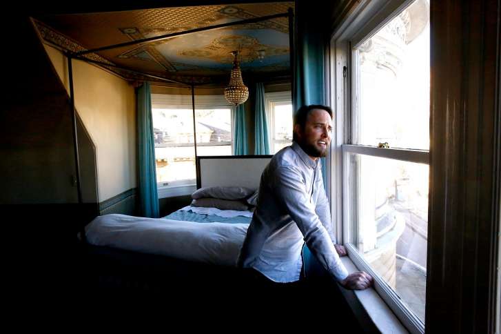 Ryan Booth in his living room he turned into his bedroom in San Francisco, Calif., on Monday Feb. 5, 2018.  Booth is able to afford his San Francisco flat  by renting out his bedroom down the hall through Airbnb.