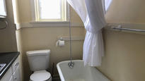 This photo from a rental ad provided by S.F. Shannon Real Estate Management LLC shows a toilet and bathtub in the kitchen of a 200-square-foot apartment in St. Louis. The toilet, bathtub, oven and sink all share a room. A St. Louis man is the new tenant of the tiny apartment. (S.F. Shannon Real Estate Management LLC via AP)
            