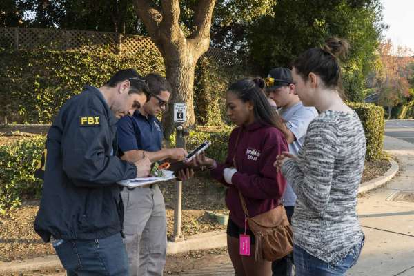 Jasmine Alexander, 25, center, speaks to an FBI agent Friday to recover her car, which she left near Borderline Bar and Grill in Thousand Oaks, California. Alexander was in the bar Wednesday during the mass shooting. She hurt her left hand while climbing out of a window.