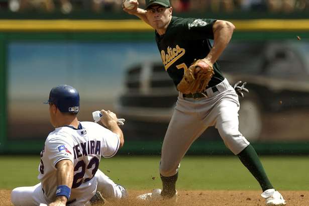 Oakland Athletics shortstop Bobby Crosby, right, tries to throw out Texas Rangers' David Dellucci at first base after getting the force out on Texas' Mark Teixeira at second during the third inning, Thursday, Sept. 23, 2004, in Arlington, Texas. Dellucci was safe at first. (AP Photo/Tony Gutierrez)