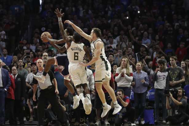 Los Angeles Clippers' Lou Williams puts up a shot under defense by Milwaukee Bucks' Eric Bledsoe and Pat Connaughton with less than 2 second left in overtime of an NBA basketball game Saturday, Nov. 10, 2018, in Los Angeles, to give the Clippers 128-126 win. (AP Photo/Jae C. Hong)