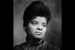 Black-and-white image of Ida B. Wells in black and white attire in front of grey background