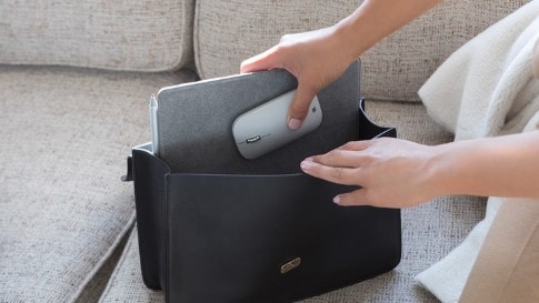Woman puts Surface Lingo and Surface Mobile Mouse in her purse