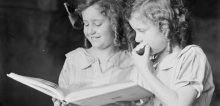 Portrait of two girls, Adelie and Toni Hurley, reading a book
