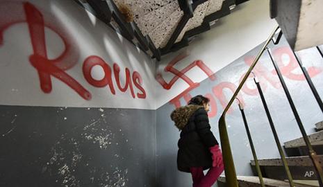 Anti-immigrant graffiti in apartment building stairwell (AP photo)