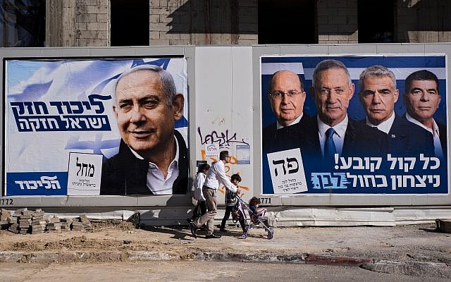 People walk by election campaign billboards showing Prime Minister Benjamin Netanyahu, left, alongside Blue and White party leaders, from left to right, Moshe Ya'alon, Benny Gantz, Yair Lapid and Gabi Ashkenazi, in Tel Aviv, April 3, 2019. Hebrew on billboards reads, left, "A strong Likud, a strong Israel," and on the right, "Every vote counts, Blue and White victory." (AP Photo/Oded Balilty)