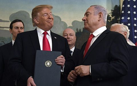 US President Donald Trump smiles at Israeli Prime Minister Benjamin Netanyahu, right, after signing a proclamation formally recognizing Israel's sovereignty over the Golan Heights, in the Diplomatic Reception Room at the White House in Washington, March 25, 2019 (AP Photo/Susan Walsh)
