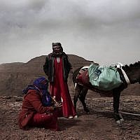 In this March 30, 2019 photo, Umm Yasser, the first Bedouin female guide from the Hamada tribe, looks at Umm Soliman as she plays the flute, near Wadi Sahw, Abu Zenima, in South Sinai, Egypt. (AP Photo/Nariman El-Mofty)