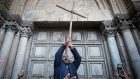 متظاهرون يحتجون من أمام الأبواب المغلقة لكنيسة القيامة في البلدة القديمة في مدينة القدس، 27 فبراير، 2018. (Yonatan Sindel/Flash90)