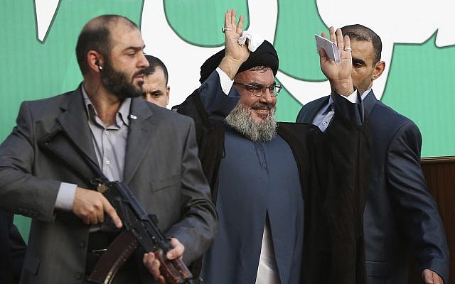 In this photo from September 17, 2012, Hezbollah leader Hassan Nasrallah, center, escorted by his bodyguards, waves to a crowd of tens of thousands of supporters during a rally in Beirut, Lebanon. (AP Photo/Hussein Malla, File)