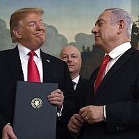 US President Donald Trump smiles at Israeli Prime Minister Benjamin Netanyahu, right, after signing a proclamation formally recognizing Israel's sovereignty over the Golan Heights, in the Diplomatic Reception Room at the White House in Washington, March 25, 2019 (AP Photo/Susan Walsh)