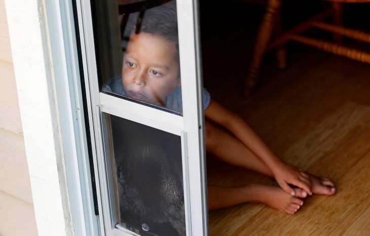 Jordan Beck-Clark, 8, peers through a window into the backyard of his Scotts Valley home on August 8, 2017.