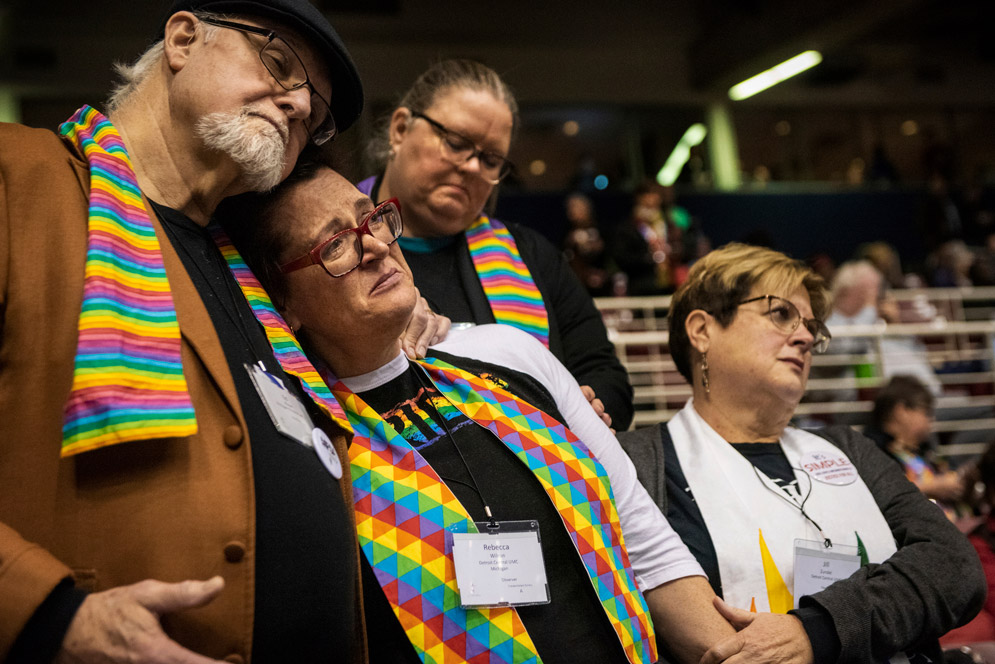 Pro-LGBTQ Methodists comfort each other after the Methodist Church delegates stiffened rules against LGBT clergy and same-sex marriage