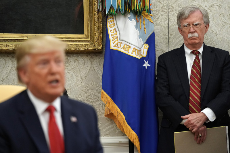White House National Security Advisor John Bolton listens to U.S. President Donald Trump as he and Dutch Prime Minister Mark Rutte talk to reporters in the Oval Office at the White House on July 18.