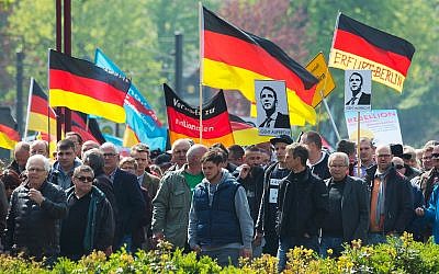 People hold flags during a demonstration by Germany's nationalist party AfD (Alternative for Germany) on May Day in Erfurt, central Germany, May 1, 2017. (AP Photo/Jens Meyer)