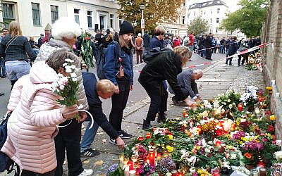People place flowers in front of the synagogue in Halle, Germany, where a memorial has been placed for the victims of Wednesday's shooting. October 11, 2019. (Yaakov Schwartz/ Times of Israel)