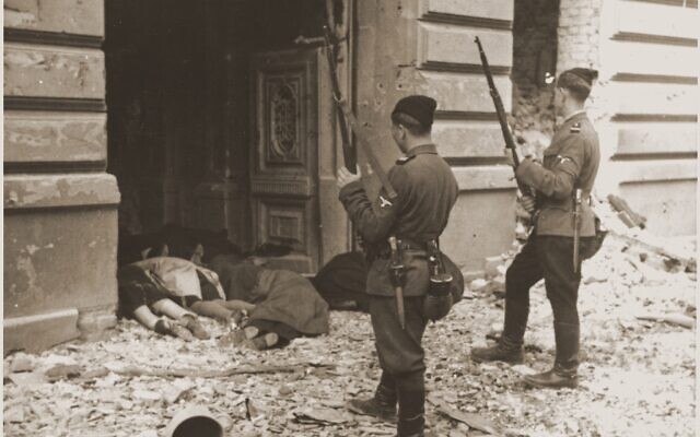 Askari or Trawniki guards peer into a doorway past the bodies of Jews killed during the suppression of the Warsaw   ghetto uprising. (Courtesy of US Holocaust Memorial Museum)