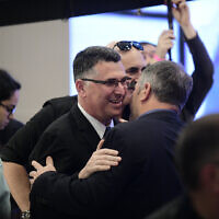 Likud MK Gideon Saar (L) embracing MK Yoav Kisch at a party conference in Ramat Gan, March 4, 2019. (Tomer Neuberg/Flash90)