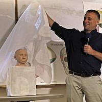 Liran Carmel of the Hebrew University reveals a 3D printed model of the face of prehistoric human species Denisovan during a press conference at the Hebrew University in Jerusalem on September 19, 2019. (MENAHEM KAHANA / AFP)