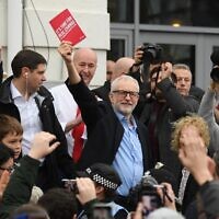 Britain's opposition Labour party leader Jeremy Corbyn holds his party's manifesto book aloft as he addresses a crowd outside the venue of a general election campaign event in Swansea, south Wales on December 7, 2019. (DANIEL LEAL-OLIVAS / AFP)