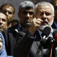 Ismail Haniyeh, leader of the Hamas terror group, announces the arrest of the alleged killer of Hamas terror orchestrator Mazen Faqha, who was shot dead on March 24, 2017 near his home in Gaza City.  Faqha's wife is alongside Haniyeh. (AFP PHOTO / MOHAMMED ABED)
