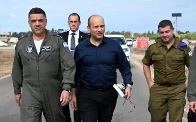 Defense Minister Naftali Bennett, book in hand, and Air Force commander Maj. Gen. Amikam Norkin, left, during a visit to the Hatzor Air Force Base on December 3, 2019. (Twitter screen capture)