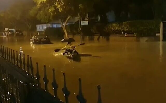 People paddle down a flooded road in the southern Israeli city of Ashkelon on Sunday December 12, 2019 (Screencapture/YouTube)
