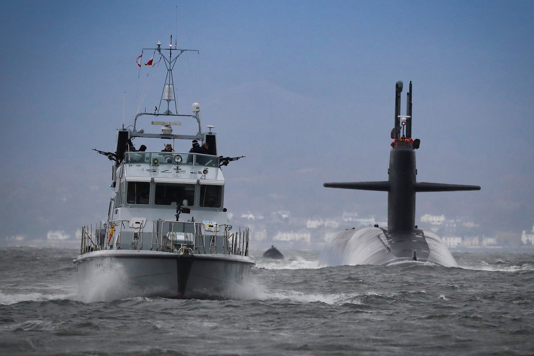 A submarine and boat drive past one another.